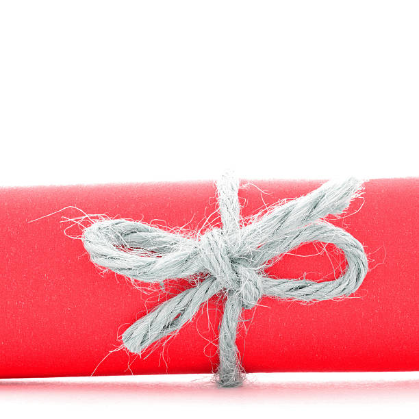 istock Handmade natural rope knot tied on red paper scroll isolated 504011554