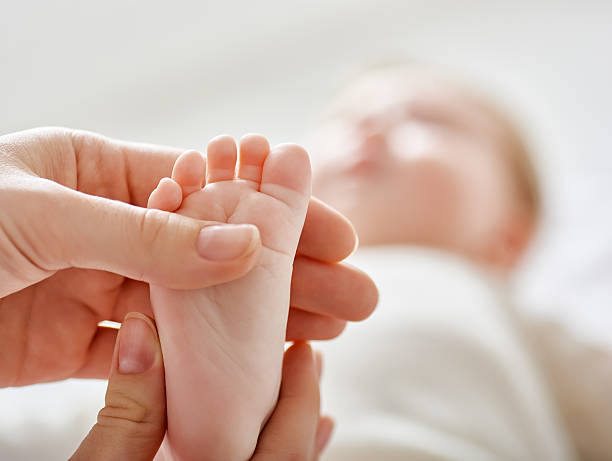 medico esaminando un bambino - piede umano foto e immagini stock