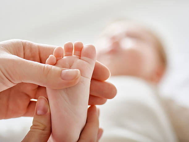 doctor examining a baby doctor examining a baby in a hospital human foot stock pictures, royalty-free photos & images