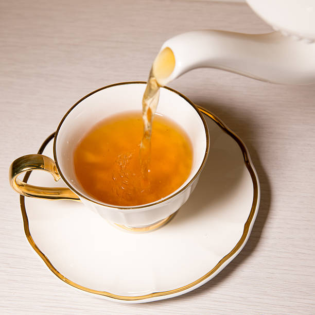 istock Tea being poured into tea cup,Isolated on white background. 504018000