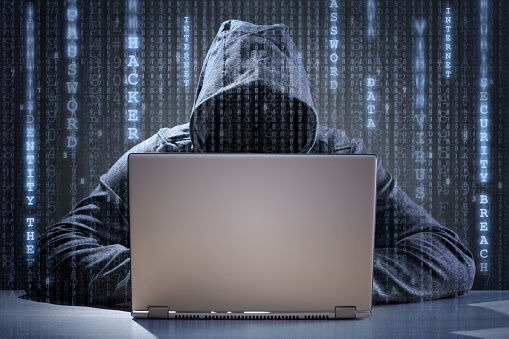 Computer hacker stealing data from a laptop concept for network security, identity theft and computer crime