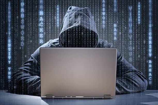 Photo of Computer hacker stealing data from a laptop