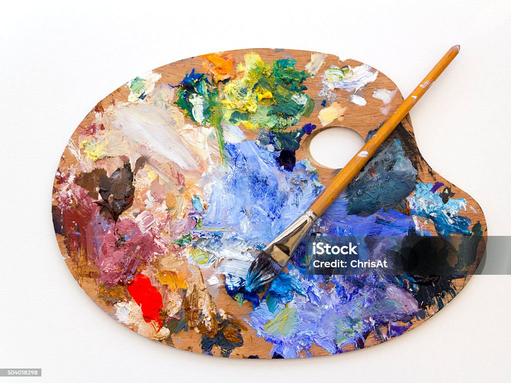 Colourful artists oil paint palette and brush on white Colourful artists oil paint palette and brushes close up on plain background Artist's Palette Stock Photo