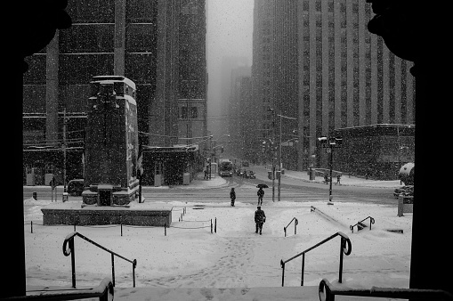 Pedestrians cross the street in the snow
