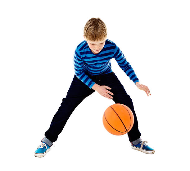 istock Blond schoolboy bouncing basketball. Isolated on white. 504030961