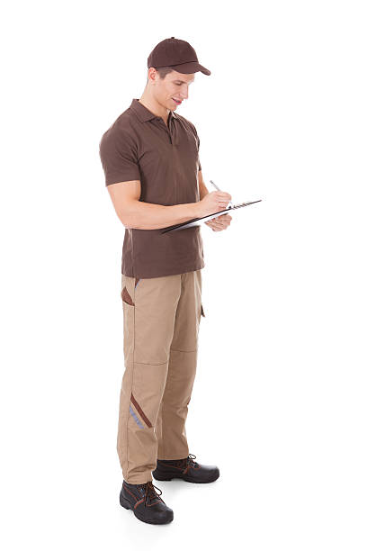 istock Young Delivery Man Writing On Clipboard 504031001