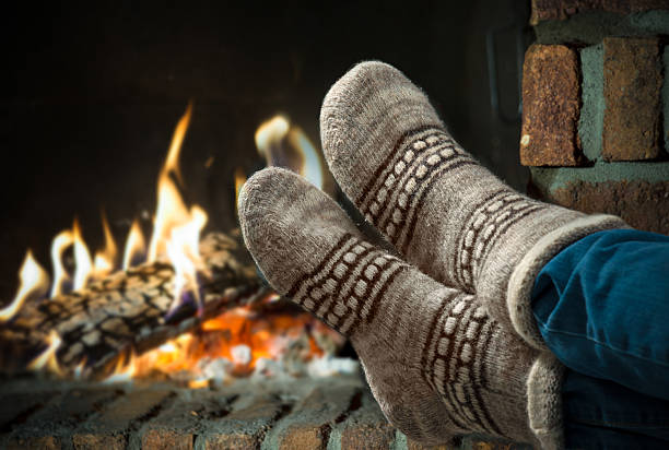 istock Feet in wool socks warming at the fireplace 504033325