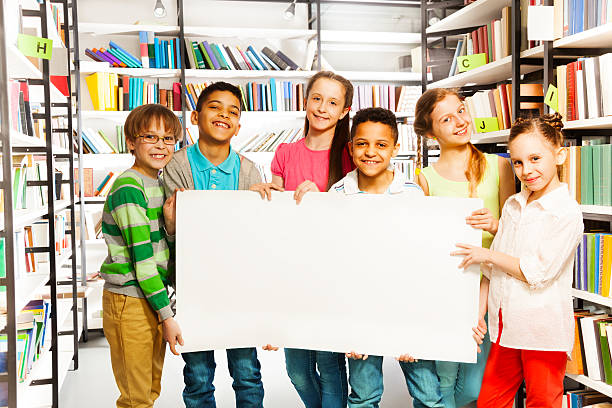 istock Friends holding white paper sheet in library 504035051