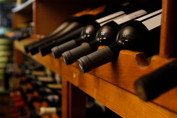 muchas de las botellas de vino en una fila - wine cellar fotografías e imágenes de stock