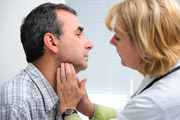 thyroid function examination female doctor touching the throat of a patient in the office lymph node photos stock pictures, royalty-free photos & images