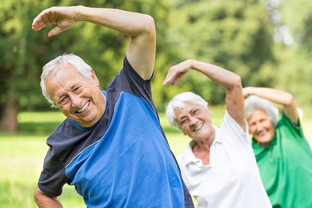 senior-ginnastica nel parco - yoga exercising outdoors group of people foto e immagini stock