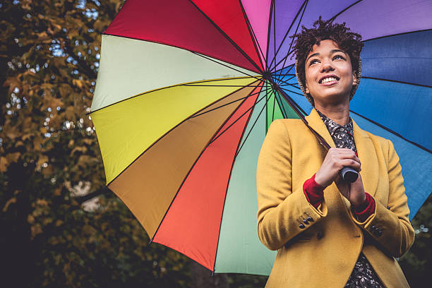 istock Smiling woman with a multi colored umbrella 504037409