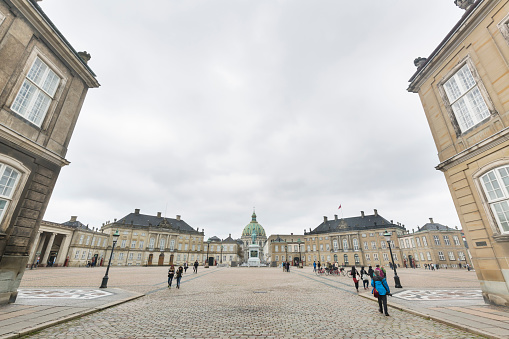 Copenhagen, Denmark - September 14, 2014: Gray clouds over the Amalienborg Palace and Square Copenhagen, Denmark with few tourists looking at the royal residence.