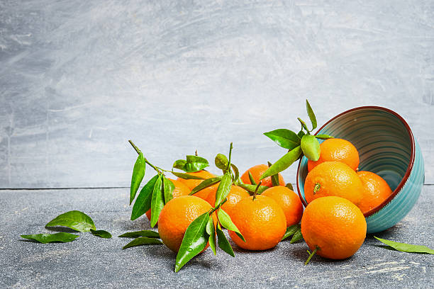 istock Tangerines with leaves and bowl on rustic background, side view 504038344