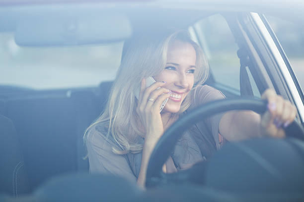 istock Young smiling woman using phone in a car 504039808