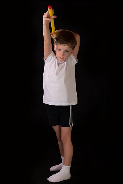 istock Boy athlete performs exercises with gymnastic stick in the gym 504042118
