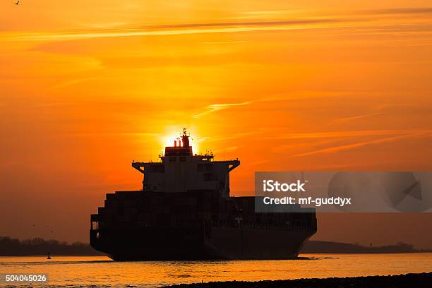 Cargo Ship In The Sunset Stock Photo - Download Image Now - Back Lit, Blue, Business