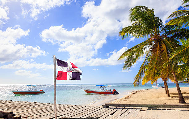 playa caribeña y la bandera de la república dominicana - república dominicana fotografías e imágenes de stock