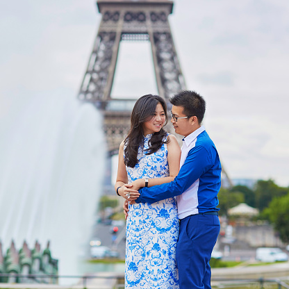 Couple hugs and kisses by Eiffel Tower