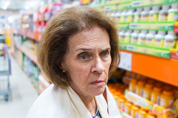 seria donna anziana in farmacia - senior adult aging process supermarket shopping foto e immagini stock