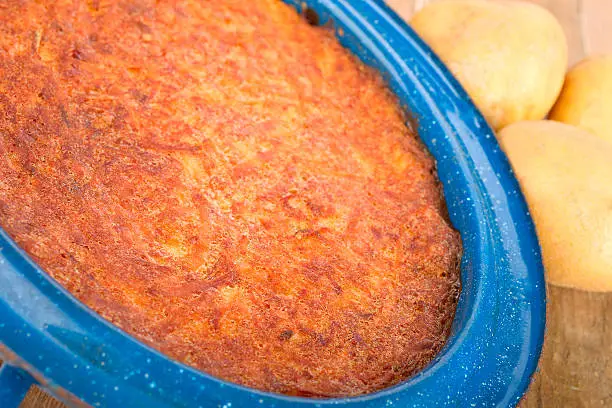 Homemade oven potato pancake in a blue baking dish.
