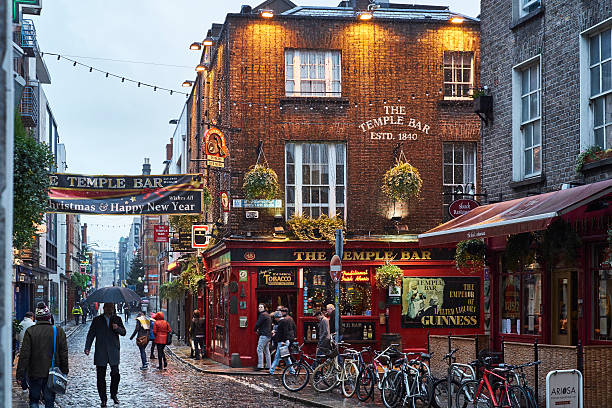 The Temple Bar Dublin, Ireland - January 5, 2016: Pedestrians walking around street in Temple Bar during rainy evening. The area is the heart of tourism in the city. dublin republic of ireland stock pictures, royalty-free photos & images