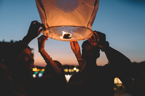 Group of  friends on the rooftop releasing chinese lantern