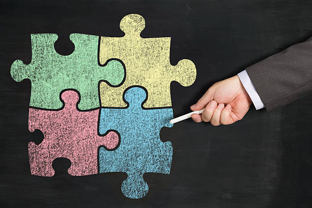 istock Four hand drawn colour jigsaw pieces on a chalkboard 504054737