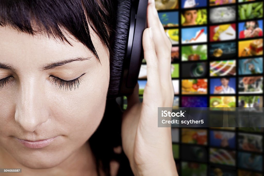 Nice Music. Woman enjoying music. Young woman with headphones, enjoying nice music. Television Set Stock Photo