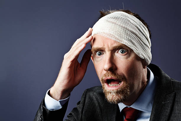 istock Horrified businessman with bandaged head cannot believe his eyes 504055785