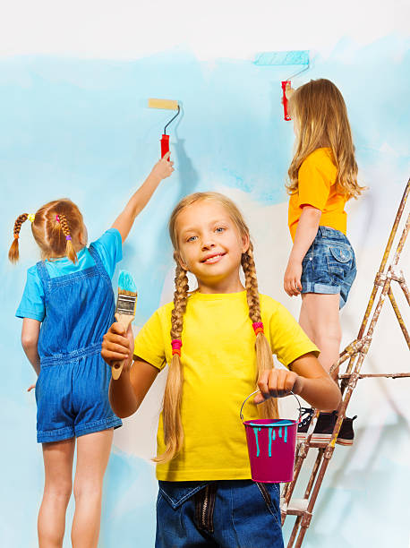 istock Three little girls against the blue wall 504056201