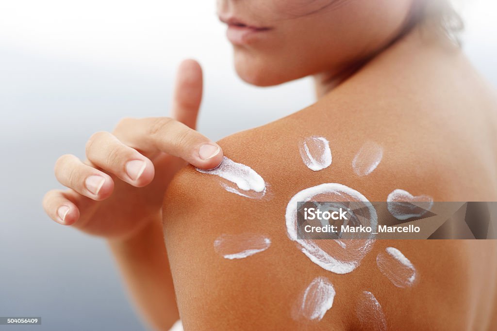 Dark tanned body in summer Dark tanned body of young woman in summer with sunscreen  lotion in shape of sun Sun Stock Photo