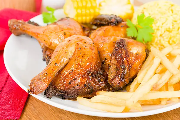 Spatchcocked poussin grilled with piri piri sauce served with fries, rice and corn on the cob.