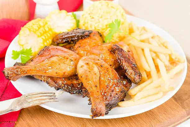Spatchcocked poussin grilled with piri piri sauce served with fries, rice and corn on the cob.