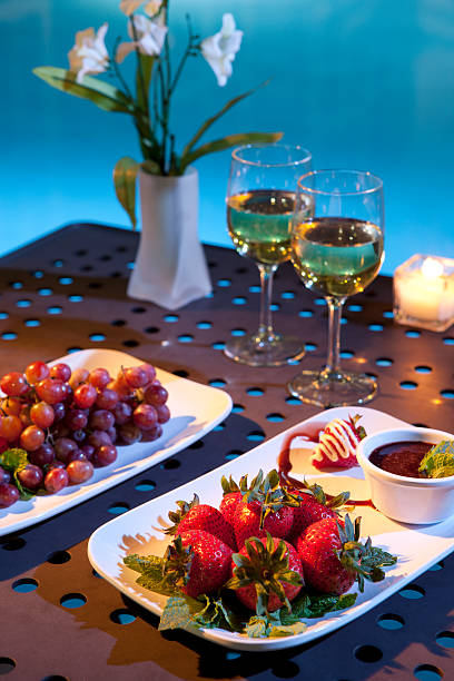 Wine and fruit next to pool stock photo