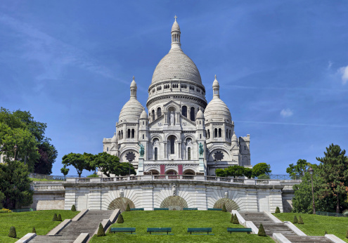 View of the Sacre Coeur (church) in Paris, France. Photo from a different angle than usual with the small tower of Notre Dame de Lorette (church) in the foreground. Photo taken during sunset from Rue Lafitte.