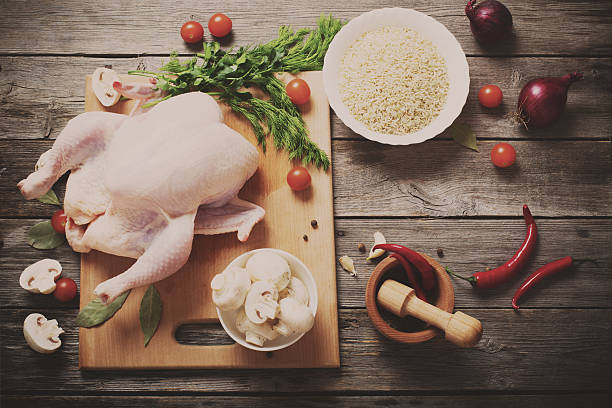 Whole raw chicken on a wooden table