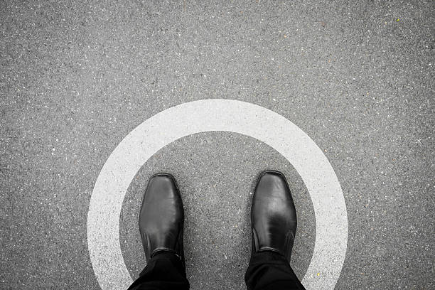istock Black shoes standing in white circle 504069444