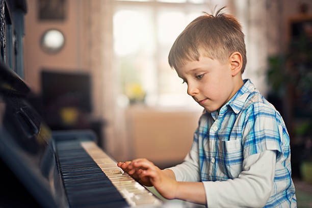 istock Little boy playing on grandmother piano 504069488