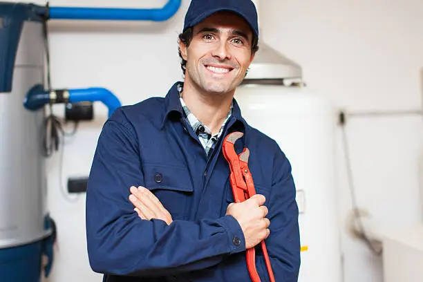 Smiling technician repairing an hot-water heater