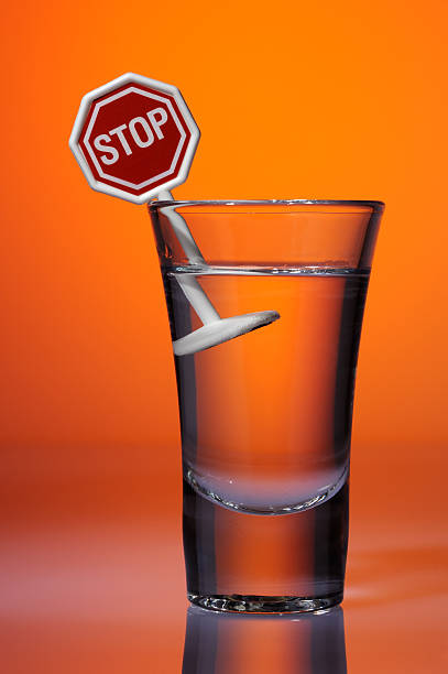 Road sign STOP in a shot glass with alcohol stock photo