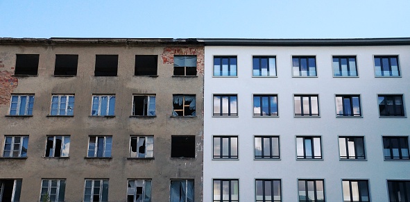 Row of old windows with shutters and flower boxes with geraniums