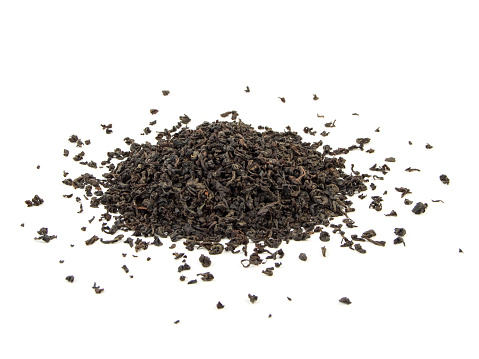 dry black tea leaves isolated on white.