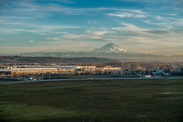 Mount Rainier rises above warehouses in Kent, Washington.