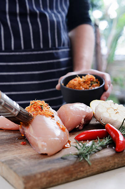 istock Rubbing spice mixture on raw chicken breasts 504077789
