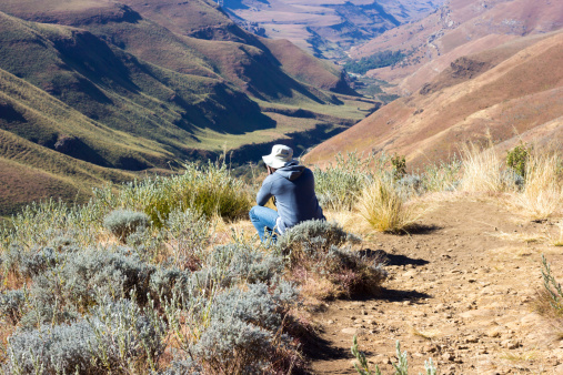 Sani Pass, South Africa - May 22, 2014: A tourist admires the view on Sani Pass between South Africa and Lesotho.