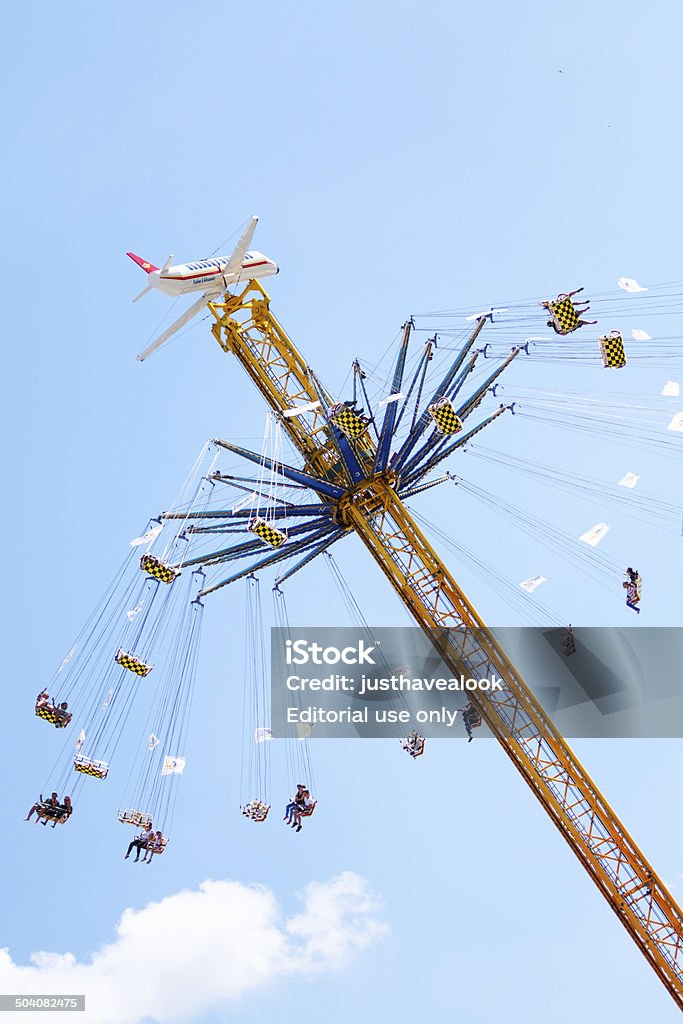 On chairoplane up in sky Düsseldorf, Germany - July 16, 2014: Capture of people in seats of moving chairoplane high up in sky on summer fun fair in Düsseldorf Oberkassel. Chain - Object Stock Photo