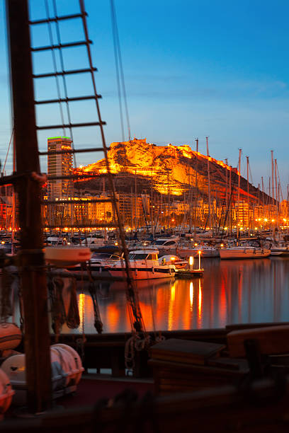 istock yachts against Castle  in night. Alicante 504082989