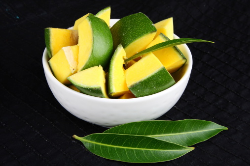 Organic green mango cuts in a bowl.