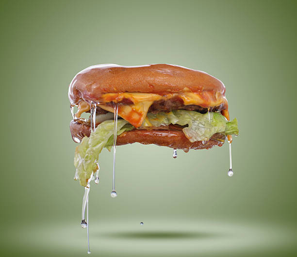 Truth behind fast food Oil covered fast food burger floating grotesque stock pictures, royalty-free photos & images